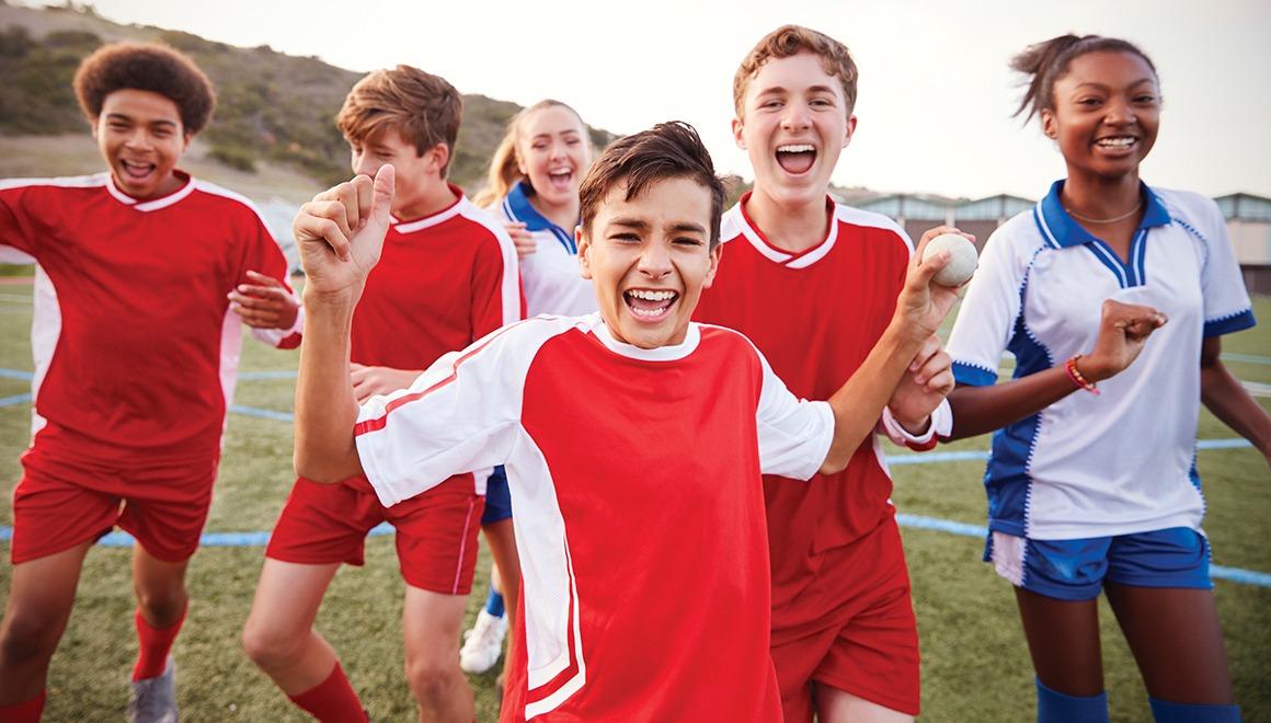 Portrait Of Male And Female High School Soccer Teams Celebrating